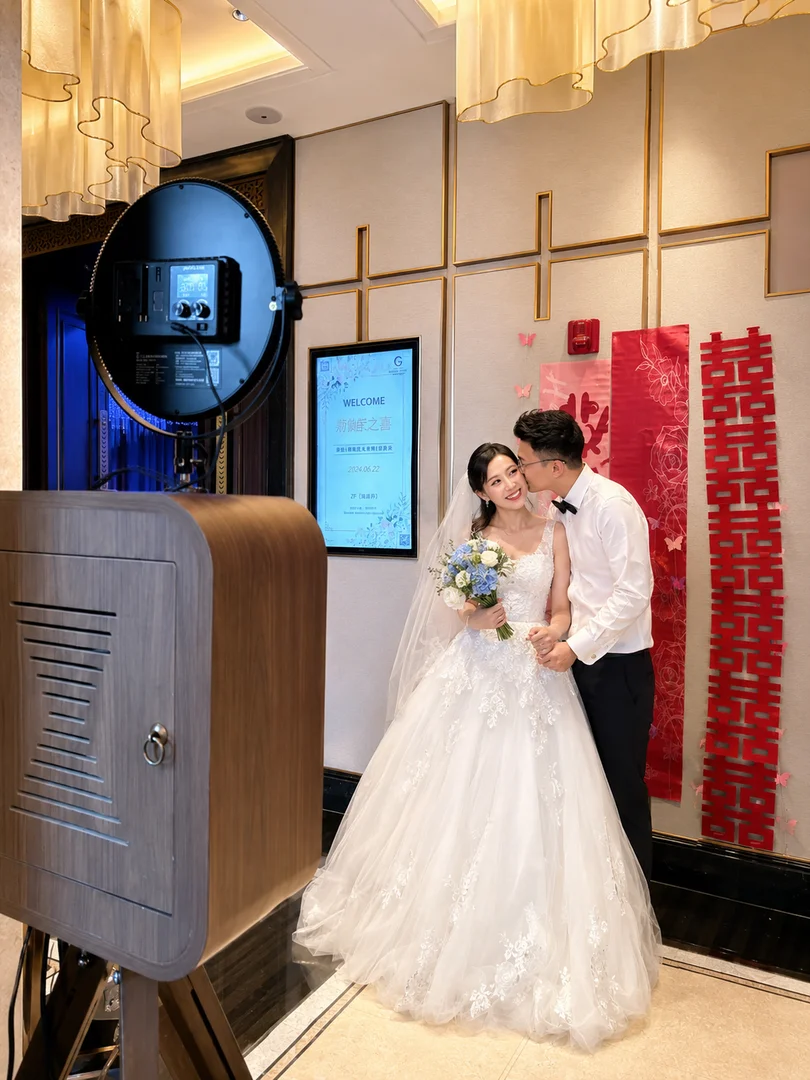 AI-generated illustration of a wedding couple beside a wooden photo booth; not an actual event photo